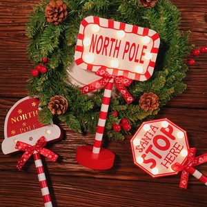 Three LED Christmas STOP signs with North Pole text on a festive wooden tabletop