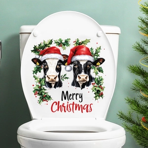 Merry Christmas cow sticker on a white toilet lid with holly leaves and festive holiday decor