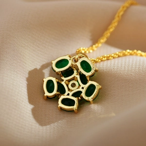 Detailed close-up of the gold-plated flower pendant with inlaid green malachite stones