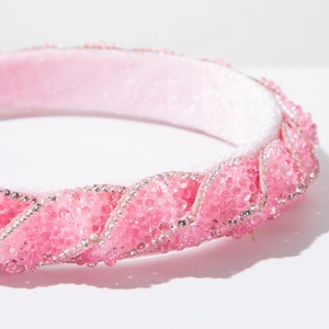 Dettaglio macro del cerchietto rosa con perline e strass argentati brillanti a spirale