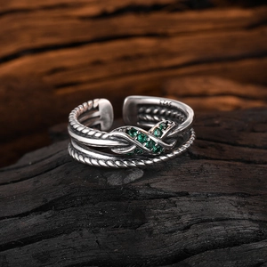 Vintage S925 sterling silver twist ring with a green zircon infinity knot on dark wood