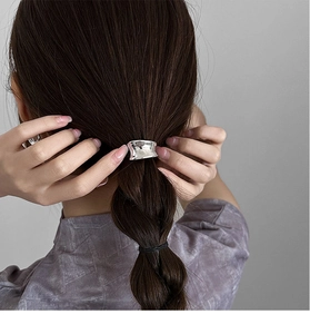 Detail of silver lava-textured metal hair cuff on a ponytail with a minimalist design