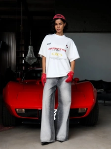 Oversized λευκό t-shirt με γραφικά αγώνων και φαρδύ γκρι τζιν παντελόνι