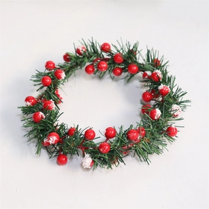 Detailed view of artificial Christmas candle ring with pine needles and snowy red berries