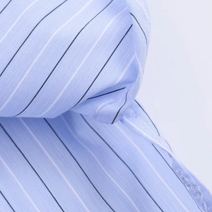 Detail of blue striped cotton shirt fabric showing fine stitching and high-quality texture
