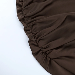 Gros plan détaillé du tissu en satin marron foncé avec texture élégante à fronces