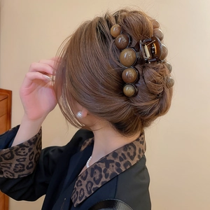 Amber acrylic hair claw clip for women shown on back of head for elegant styling