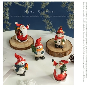 Detailed view of resin Santa and snowman figurines in a cozy Christmas scene setup