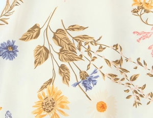 Detailed macro shot of floral fabric with sunflower and wildflower prints on beige base