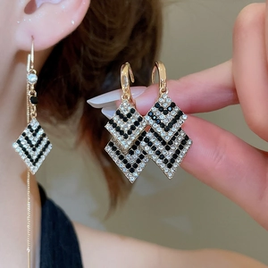 Gros plan des boucles d'oreilles losanges élégantes et détail du tour d'oreille doré