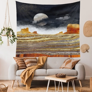 Artistic abstract mountain wall tapestry hanging above a modern grey sofa in a living room
