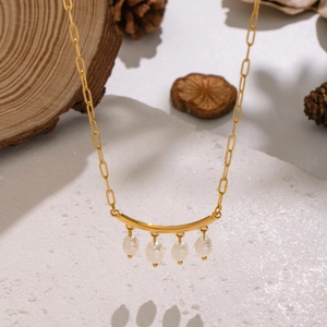 Collier élégant en acier inoxydable doré avec perles d'eau douce naturelles sur fond texturé