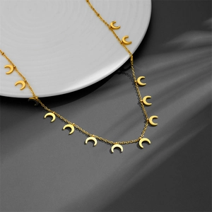 Minimalist gold stainless steel necklace with multiple crescent moon pendants on a white disk