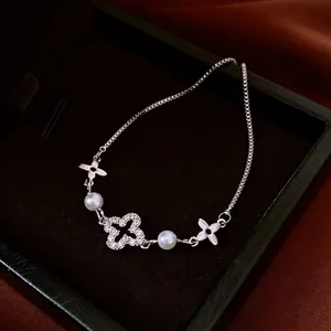 Adjustable silver flower bracelet with pearls and zircon crystals on black velvet