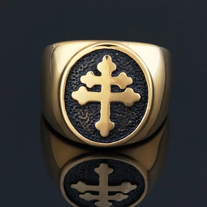 Detailed macro view of a gold-toned stainless steel ring with an embossed Lorraine cross