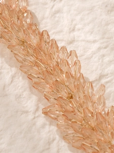 Detail of pink crystal beaded bridal headband with hand-woven leaf-shaped drop stones