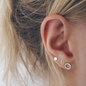 Juego de tres pendientes geométricos de plata con botones y aros en la oreja