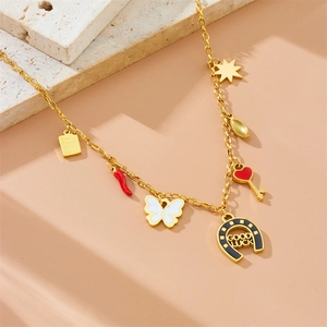 Detailed view of gold stainless steel necklace with red heart and GOOD LUCK horseshoe charms