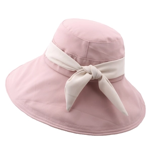 Dettaglio del cappello da sole rosa a tesa larga con nastro a fiocco beige raffinato