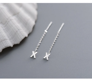 Macro shot of silver S999 sterling silver X-letter threader earrings with fine chains