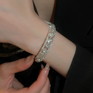 Macro detail of silver open triple-layer bracelet with brilliant zircon pavé setting