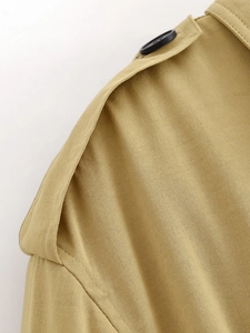 Macro view of khaki twill cotton jacket shoulder detail with epaulet and black button