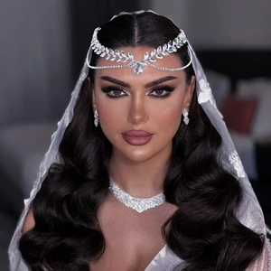 Close-up of elegant rhinestone bridal headpiece and V-shaped necklace on model