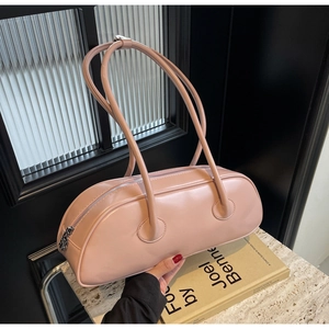 Detail of soft pink cylindrical underarm bag with smooth leather texture and silver zipper