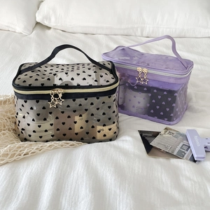 Detail of translucent mesh makeup bags with heart patterns and gold star zippers