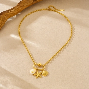 18K gold plated stainless steel necklace with seashell and starfish charms on beach background