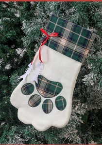 Détail d'une chaussette de Noël en forme de patte avec motif à carreaux verts et os