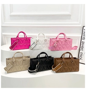 Detail view of colorful geometric quilted handbags with stylish wide shoulder straps