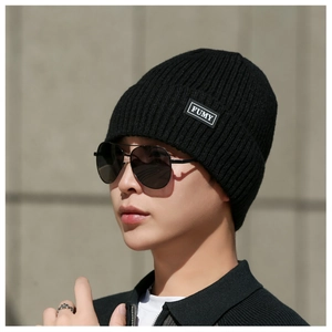 Detailed texture of black ribbed knit beanie featuring FUMY rectangular woven label tag
