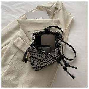 Canvas bucket bag detail showing spacious interior for phone and wallet with leather strap