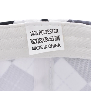 Macro detail of washing label showing 100% polyester fabric and care icons on cap