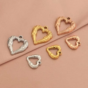 Detail of heart-shaped angel wing pendants in gold, silver, and rose gold finishes