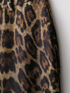 Dettaglio del tessuto in raso leopardato con trama jacquard e passante per cintura