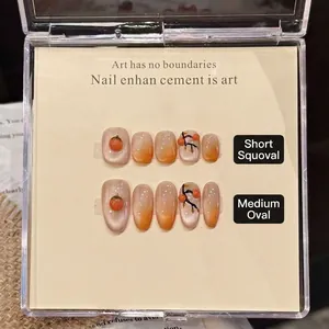 Handmade orange cat-eye press-on nails with 3D persimmon art in short squoval and oval shapes