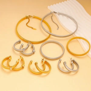 Detail of stainless steel jewelry set featuring spring textures in gold and silver