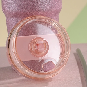 Close-up of pink glitter 30oz tumbler lid with clear sliding cover and a grey straw
