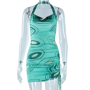 Close-up of sleeveless halter neck dress featuring abstract print and side drawstring ruching