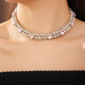Gros plan d'un collier ras-du-cou argenté double avec cristaux cœurs roses et diamants