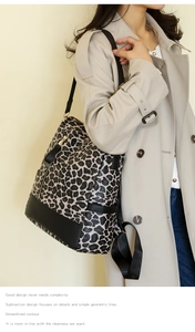 Detailed side view of leopard print backpack with black leather trim worn on a beige coat
