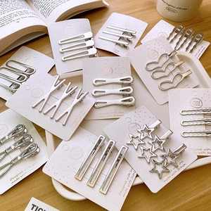 Silver Y2K metal hair clips set with star and heart shapes on a decorative tray