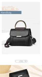 Détail d'un sac à main noir en cuir grainé avec une poignée métallique ronde dorée