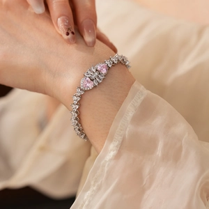 Close-up of zircon heart bracelet with pink and clear stones on model's wrist
