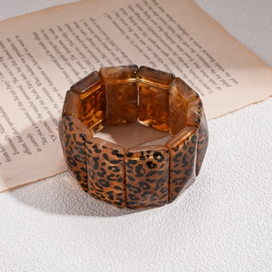 Close-up of amber leopard print resin bangle on vintage paper with high-quality texture