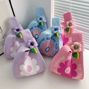 Detail of colorful knitted gift bags with floral patterns and 3D flower charms