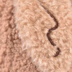 Close-up of soft brown faux shearling texture with fine embroidery on baseball cap