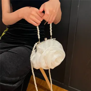 Detailed view of white organza rose evening bag with elegant pearl handle and strap